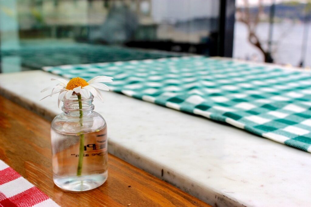 Wildflowers in a glass mason jar placed on a bright plaid tablecloth