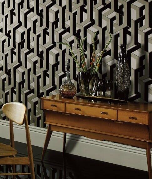 Modern geometric wallpaper in gray tones behind a mid-century console table with decorative vases and a chair